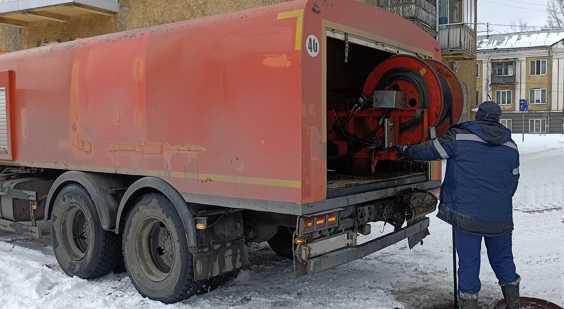 Каналопромывочная машина и работник прочищают засор в канализационной системе в Забайкальском крае